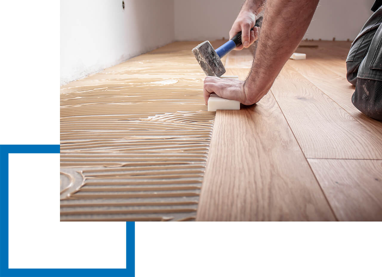 Betriebshaftpflicht Handwerker Handwerker verlegt Laminat auf Boden