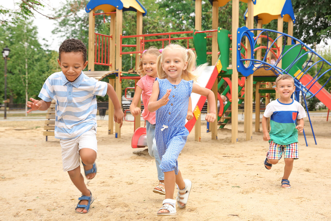 Berufshaftpflichtversicherung für Erzieher | Tarife ab 5,55 € mtl. Glückliche Kinder spielen auf einem Spielplatz.