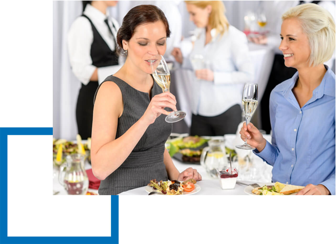 Betriebshaftpflicht Catering - Zwei attraktive Frauen stoßen mit Champagner an