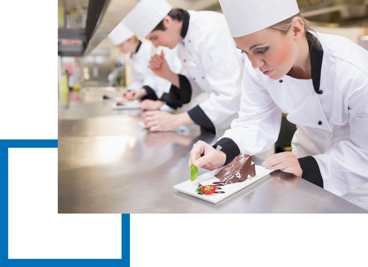 Betriebshaftpflicht Koch Betriebshaftpflicht - Köchin verziert Schokokuchen