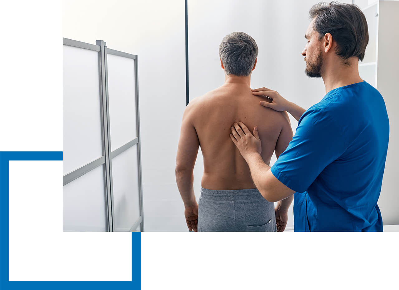 Osteopath untersucht Mann am Rücken