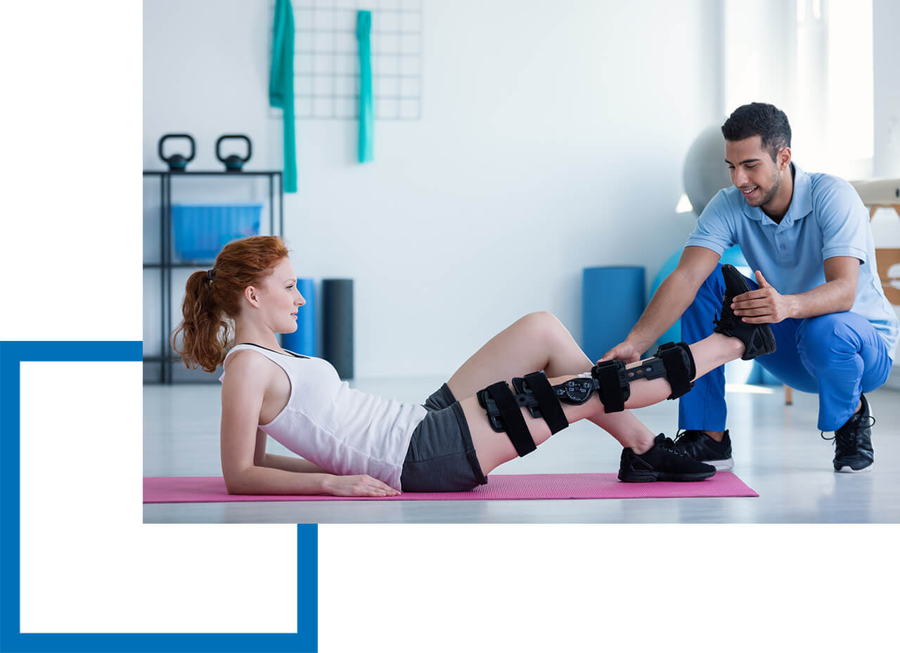 Physiotherapeut behandelt Patientin am Bein in Praxis