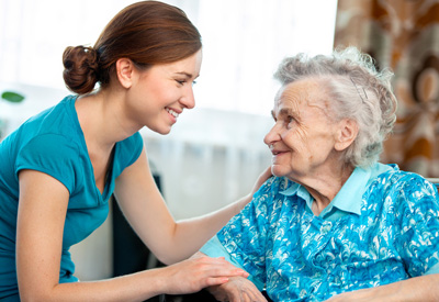 Altenpflegerin kümmert sich um eine ältere Frau