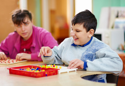 Heilpädagoge fördert spielerisch geistig behinderte Kinder