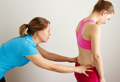 Junge Patientin hat eine Physiotherapie-Behandlung aufgrund Ihrer Rückenschmerzen