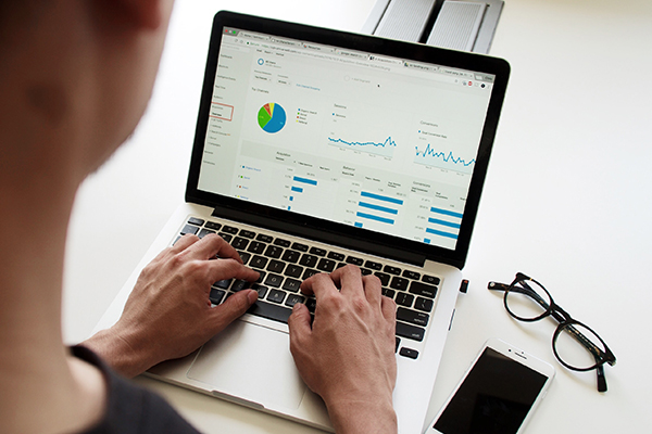 Als Agentur für Marketing haben Sie viele Risiken zu tragen - Sichern Sie sich jetzt durch eine Berufshaftpflichtversicherung ab, um die Last von den Schultern zu verlieren Kennzahlenanalyse von einer Marketingkampange am Laptop