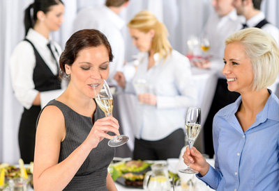 Betriebshaftpflicht Catering - Zwei attraktive Frauen stoßen mit Champagner an