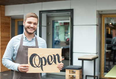 Eröffnung - Existenzgründer steht vor seinem Restaurant