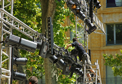 Licht- und Tontechniker montiert Scheinwerfer an einem Bühnengerüst