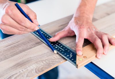 Bodenleger beim Zuschneiden von Laminat