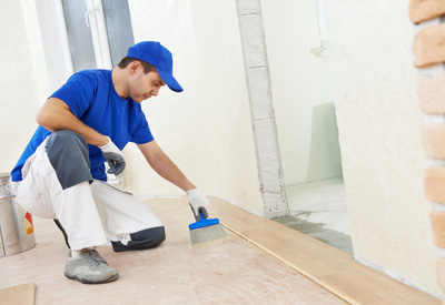 Handwerker verlegt Laminat - versichert mit einer Haftpflicht