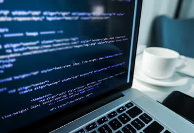 IT-Unternehmer programmiert html-Code auf Laptop